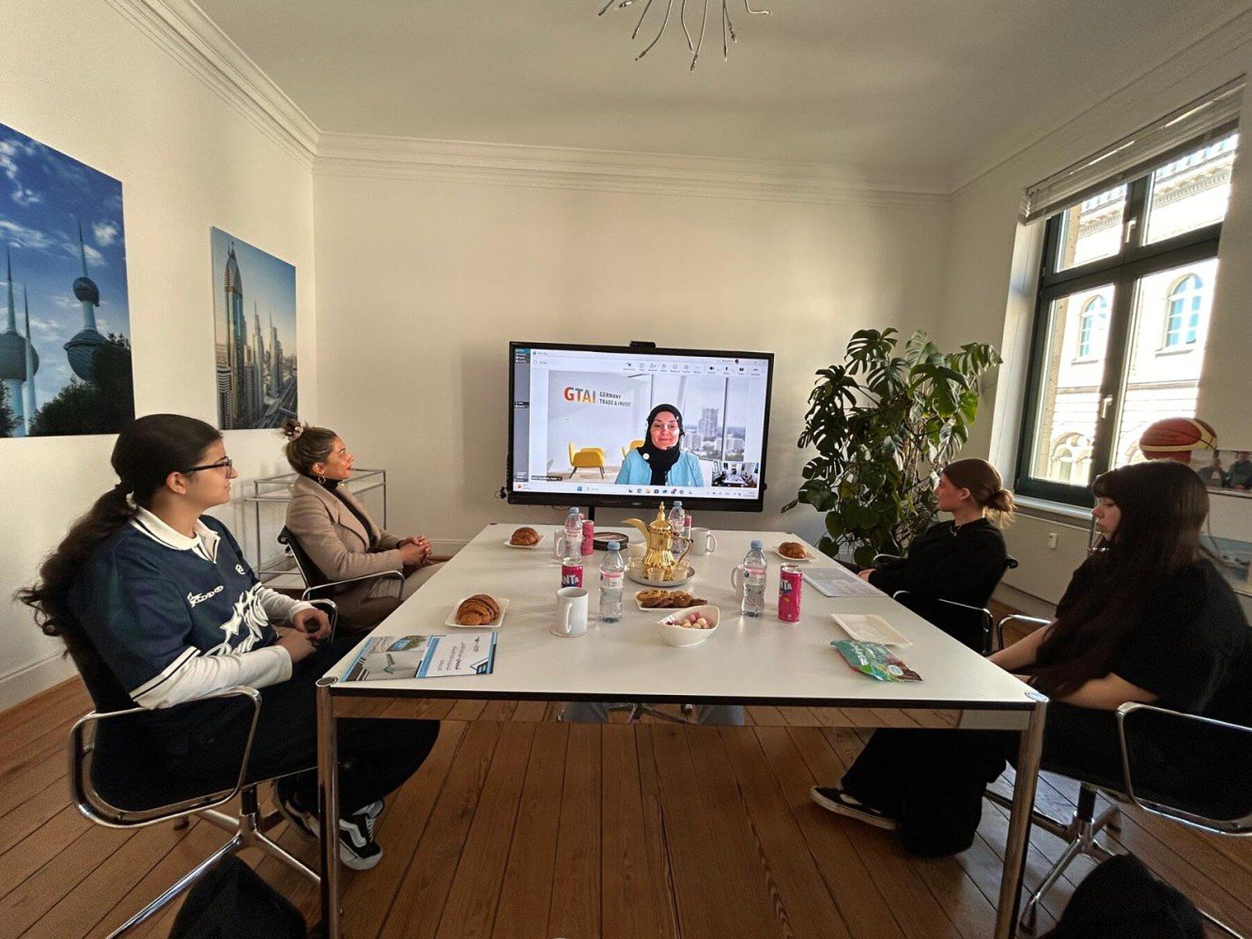 Teilnehmerinnen des Girls’Day im Besprechungsraum von EL-ṮAMER in Bonn, auf dem Bildschirm eine Referentin von Germany Trade & Invest